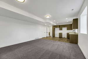 Unfurnished living room with dark carpet and recessed lighting