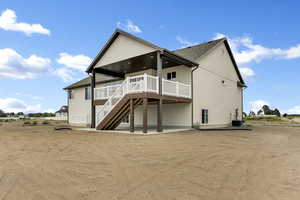 Rear view of property featuring a patio, a deck, stairs, and roof with shingles