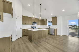 Kitchen featuring lofted ceiling, brown cabinetry, hanging light fixtures, backsplash, and a kitchen island