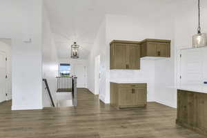Kitchen featuring decorative light fixtures, brown cabinetry, and dark wood-style floors