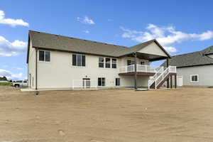 Back of house with a patio, stairs, roof with shingles, a wooden deck, and stucco siding