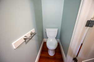 Bathroom featuring baseboards and dark wood-type flooring