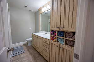 Bathroom with light tile patterned flooring and vanity