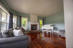 Living room featuring dark wood-style floors, a fireplace, and recessed lighting