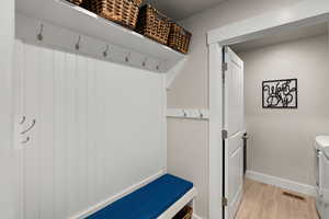 Mudroom with light wood finished floors and washer and dryer