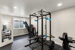 Exercise room with baseboards and recessed lighting