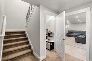 Staircase with carpet flooring and recessed lighting