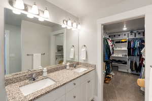 Full bathroom featuring double vanity and a walk in closet