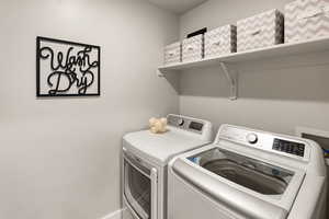 Laundry area with washing machine and clothes dryer and baseboards