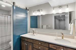 Full bath featuring double vanity, recessed lighting, and a shower with curtain