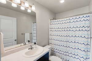 Full bath with vanity, shower / bathtub combination with curtain, and recessed lighting