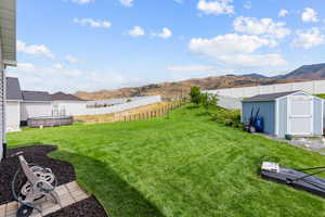 Fenced backyard with a mountain view and a storage shed
