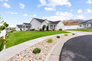 View of front of home with board and batten siding, concrete driveway, a mountain view, a porch, and an attached garage