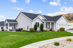 View of front of property featuring board and batten siding, roof with shingles, a front yard, and an attached garage