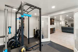 Exercise room with recessed lighting and dark colored carpet
