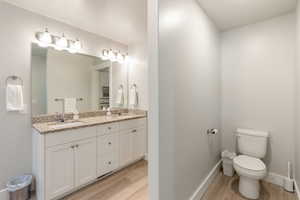 Full bathroom featuring light wood-type flooring and double vanity