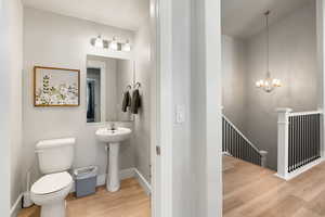 Bathroom with light wood-style flooring and a chandelier