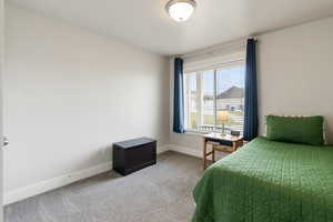 Bedroom with light colored carpet and baseboards