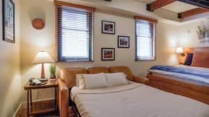 Bedroom featuring beam ceiling and baseboards