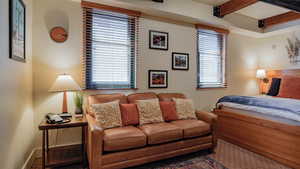 Bedroom featuring beamed ceiling and baseboards