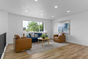 Living area with recessed lighting and light wood-type flooring