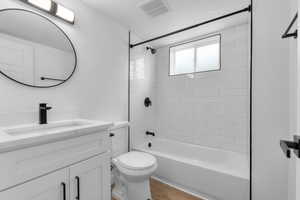 Bathroom with shower / washtub combination, vanity, and light wood finished floors