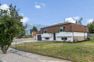 View of front of house with mansard roof, driveway, a garage, roof with shingles, and a mountain view