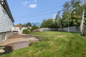 Fenced backyard featuring a deck with mountain view