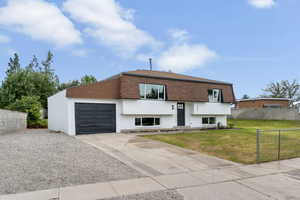 View of front of home featuring mansard roof, driveway, an attached garage, and a shingled roof