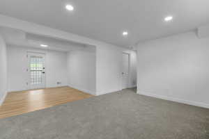 Spare room with light carpet, recessed lighting, and light wood-style floors