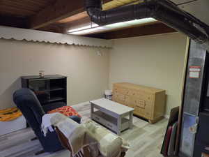 Below grade area with wood finished floors, heating unit, and wood ceiling