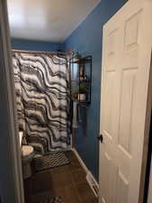 Full bath featuring toilet and baseboards