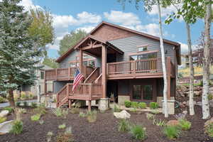 Rear view of property featuring a wooden deck and stairs