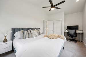 Bedroom with carpet floors, lofted ceiling, a closet, a desk, and ceiling fan