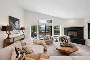 Carpeted living room featuring recessed lighting, a fireplace, and high vaulted ceiling