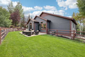 Back of house with a fenced backyard, an outdoor hangout area, and a patio area