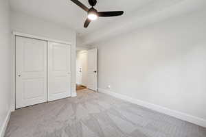 Unfurnished bedroom featuring carpet, a closet, and ceiling fan