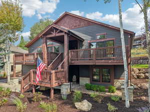 Back of property with a wooden deck and stairway