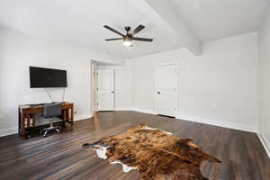 Bedroom featuring beam ceiling, ceiling fan, a desk, and dark wood finished floors