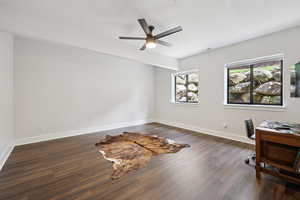 Office space featuring a textured ceiling, dark wood-type flooring, and ceiling fan