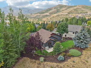 View from above of property featuring a mountainous background and a tree filled landscape