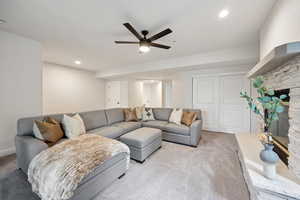 Living room featuring a fireplace, carpet floors, a ceiling fan, and recessed lighting