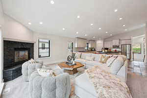 Living area with vaulted ceiling, recessed lighting, and a fireplace