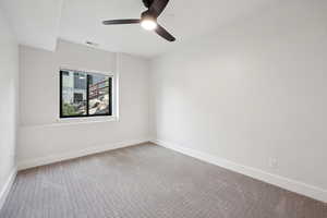 Carpeted spare room featuring baseboards and ceiling fan