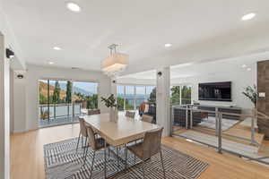 Dining space with light wood-style floors, recessed lighting, and a chandelier