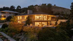 Back of property with a balcony, stucco siding, and a chimney