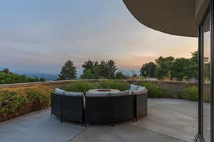 Patio terrace at dusk with a patio and an outdoor living space with a fire pit