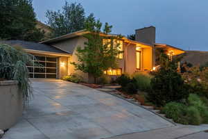 View of front facade featuring concrete driveway, stucco siding, and an attached garage