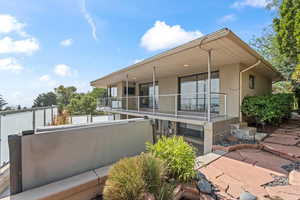 Back of property with a balcony and stucco siding