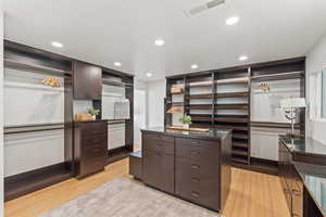 Spacious closet featuring light wood-style flooring